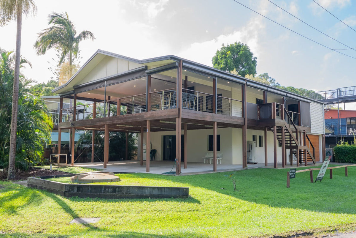 Elevated wraparound wood deck on a modern house with a lawn