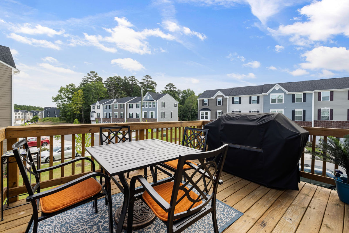 Backyard wood deck with a grill, table and chairs