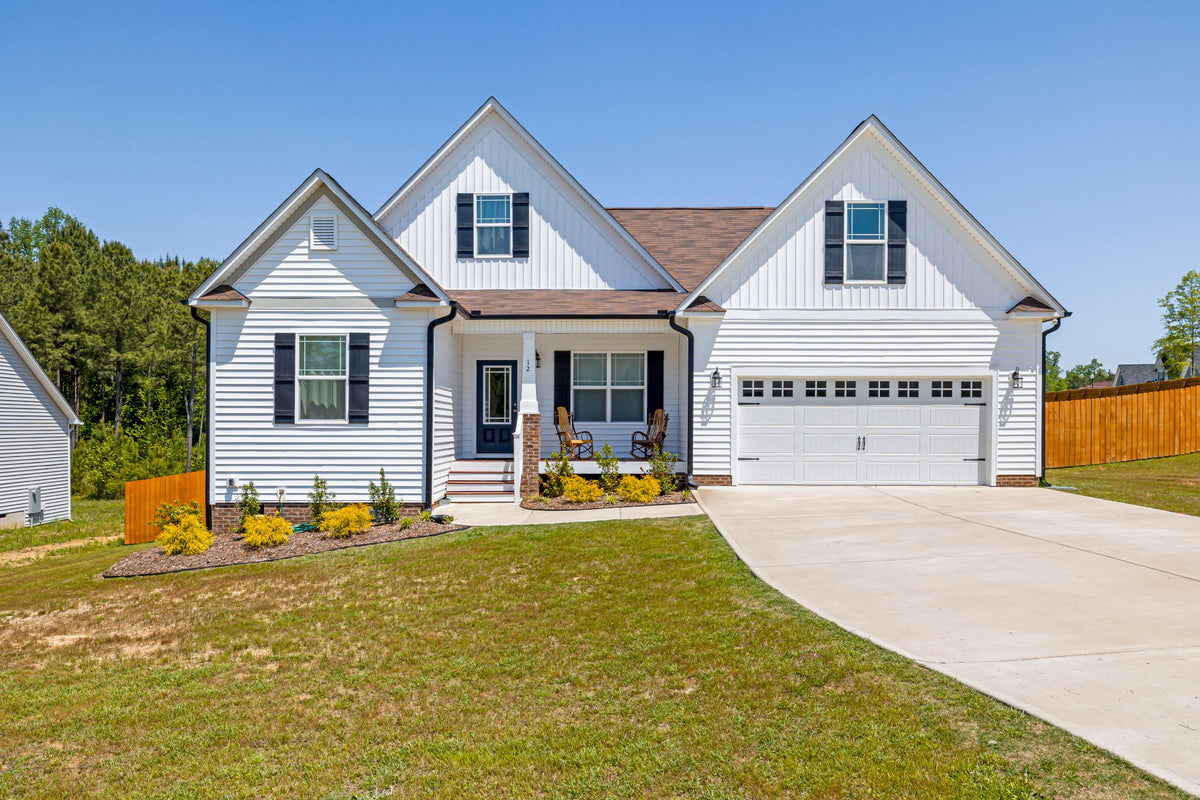 White suburban house with a clean concrete driveway